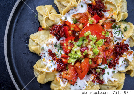 Traditional Turk manti steamed with mincemeat and paprika tomato salad Traditional Turk manti steamed with mincemeat and paprika tomato salad 75121921