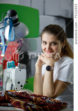 Young seamstress businesswoman at her workplace Young seamstress businesswoman at her workplace 75122835