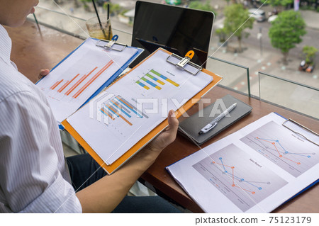 Young investor reading financial report outdoor the balcony Young investor reading financial report outdoor the balcony 75123179