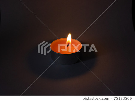 Candle on dark luxury night background. Black table, side view. Candles Burning at Night. Candle on dark luxury night background. Black table, side view. Candles Burning at Night. 75123509