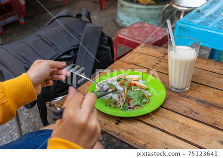 Female traveller eating Vietnamese street food - Banh Cuon Female traveller eating Vietnamese street food - Banh Cuon 75123641