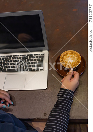 Vertical photo of woman hand holding cup of cappuccino Vertical photo of woman hand holding cup of cappuccino 75123777