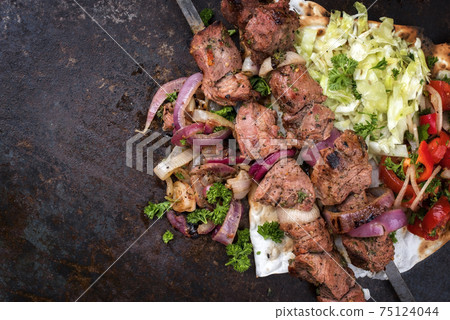 Traditional Greek souvlaki barbecue skewer with cabbage and tomato onion salad Traditional Greek souvlaki barbecue skewer with cabbage and tomato onion salad 75124044