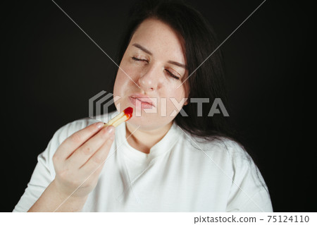 Dieting overweight woman eating french fries 75124110