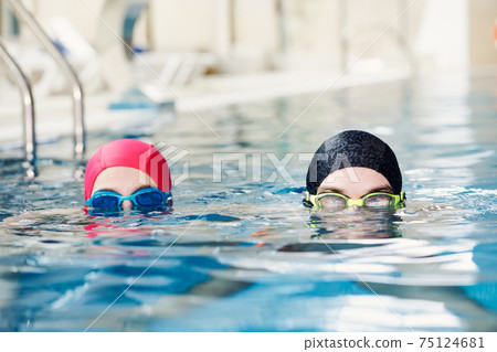 Siblings swim in a pool 75124681