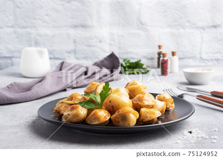 Traditional fried pelmeni, ravioli, dumplings filled with meat on black plate, russian kitchen. Gray concrete background, copy space. Traditional fried pelmeni, ravioli, dumplings filled with meat on black plate, russian kitchen. Gray concrete background, copy space. 75124952