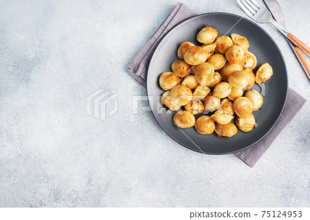Traditional fried pelmeni, ravioli, dumplings filled with meat on black plate, russian kitchen. Gray concrete background, copy space. Traditional fried pelmeni, ravioli, dumplings filled with meat on black plate, russian kitchen. Gray concrete background, copy space. 75124953