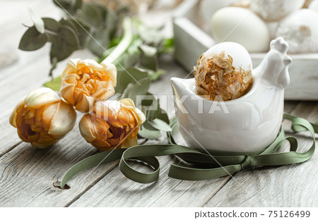 Spring easter composition with eggs and flowers on wooden surface close up. Spring easter composition with eggs and flowers on wooden surface close up. 75126499