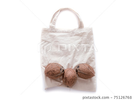 Zero waste and plastic free concept. Coconut on eco bag over white background. Flat lay. Copy space. 75126768