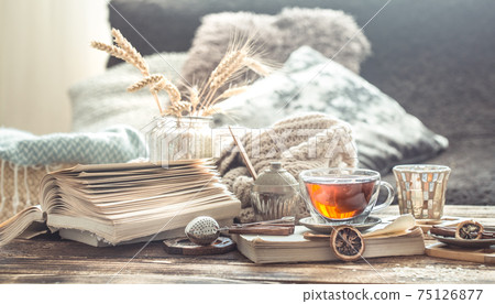 Still life details of home interior on a wooden table with a Cup of tea Still life details of home interior on a wooden table with a Cup of tea 75126877