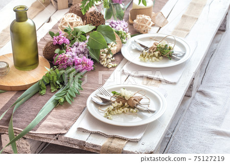 Beautifully elegant decorated table for holiday - wedding or valentine day with modern cutlery, bow, glass, candle and gift Beautifully elegant decorated table for holiday - wedding or valentine day with modern cutlery, bow, glass, candle and gift 75127219