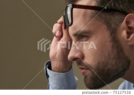 Serious attentive stare from under the eyeglasses Serious attentive stare from under the eyeglasses 75127538