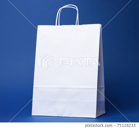 white paper disposable bag with handles on blue background 75128233