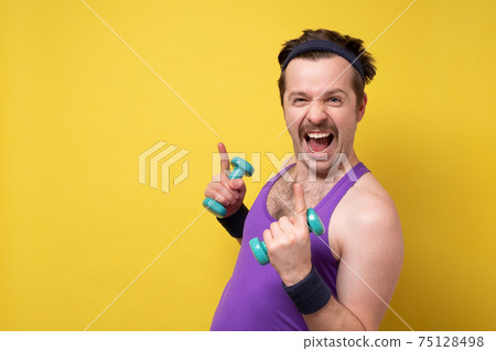 Funny sportsman which doing exercise with lightweight dumbbells and looking at camera. Funny sportsman which doing exercise with lightweight dumbbells and looking at camera. 75128498