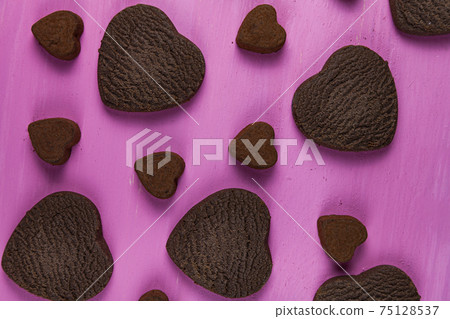 Heart shaped cookies and candies on a pink wooden background. Heart shaped cookies and candies on a pink wooden background. 75128537