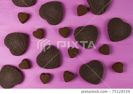 Heart shaped cookies and candies on a pink wooden background. Heart shaped cookies and candies on a pink wooden background. 75128539