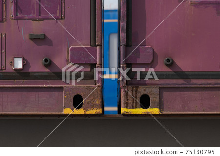 Blue train seen through the gap of the freight train 75130795