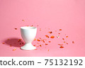 White egg stand on a pink background with blurred gold decor. 75132192