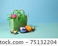 Easter eggs in a silicone basket on a blue background. 75132204