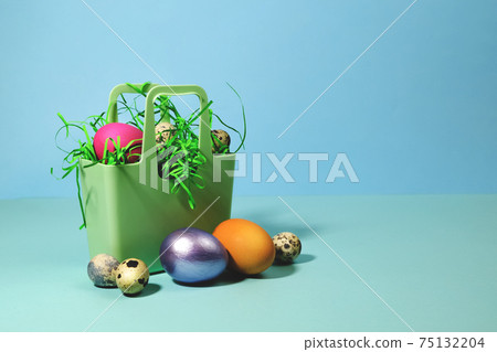 Easter eggs in a silicone basket on a blue background. Easter eggs in a silicone basket on a blue background. 75132204