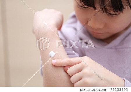 Toddler girl applying dermatological ointment cream 75133593