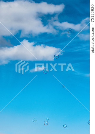 肥皂泡在蔚藍的天空和潔白的雲朵 75133920