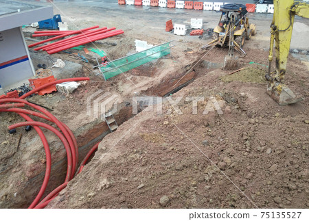 SEREMBAN, MALAYSIA -MARCH 02, 2017: Underground utility and services pipe lay by workers at the construction site. The pipes used to protect cable lay inside it. SEREMBAN, MALAYSIA -MARCH 02, 2017: Underground utility and services pipe lay by workers at the construction site. The pipes used to protect cable lay inside it. 75135527