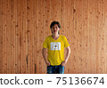 Man wearing Rhode Island flag color shirt and standing with two hands in pant pockets 75136674