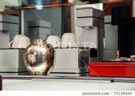 Coffee machine with cups and supplies on the shelf Coffee machine with cups and supplies on the shelf 75136949