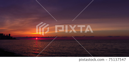 Sunset over Malecon and Atlantic Ocean with residential building in background - Havana, Cuba 75137547