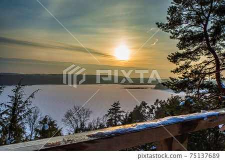 Breathtaking Sunset with Golden Clouds over Frozen Lake Breathtaking Sunset with Golden Clouds over Frozen Lake 75137689
