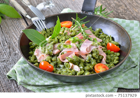 South Tyrolean spinach spaetzle with parmesan cream sauce, strips of ham and fried tomatoes 75137929