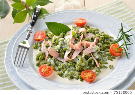 South Tyrolean spinach spaetzle with parmesan cream sauce, strips of ham and fried tomatoes 75138060