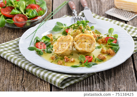 South Tyrolean bread dumplings with grey cheese, served with butter and walnuts South Tyrolean bread dumplings with grey cheese, served with butter and walnuts 75138425