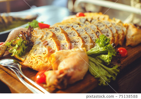 beautiful chicken and mushroom pie with herbs, tomatoes and chicken legs on a wooden board in a restaurant. Selective focus, close-up 75138588