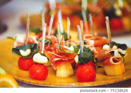 A set of beautiful canapes on golden dishes. Buffet table. Food. Fun. Close-up A set of beautiful canapes on golden dishes. Buffet table. Food. Fun. Close-up 75138626