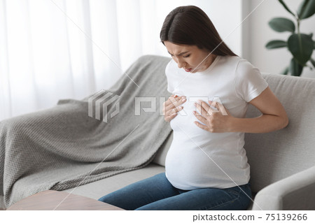 Breast Soreness. Concerned pregnant lady touching her chest area, suffering acute pain Breast Soreness. Concerned pregnant lady touching her chest area, suffering acute pain 75139266
