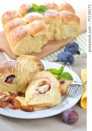 Sweet Austrian yeast pastry dumplings stuffed with plums and served with vanilla sauce 75139271