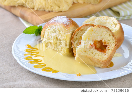 Sweet Austrian yeast pastry dumplings stuffed with apricot jam and served with vanilla sauce 75139616
