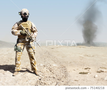Photo of a fully equipped military soldier standing with automatic rifle of war desert background. Photo of a fully equipped military soldier standing with automatic rifle of war desert background. 75140218