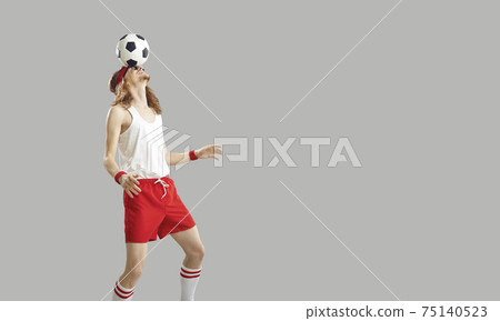 Young man in sportswear balancing soccer ball on forehead isolated on gray background Young man in sportswear balancing soccer ball on forehead isolated on gray background 75140523