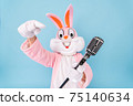 Happy funny kid boy or girl singer or vocalist sings song to retro vintage classic microphone. Easter bunny or rabbit or hare celebrates Happy easter isolated on blue 75140634