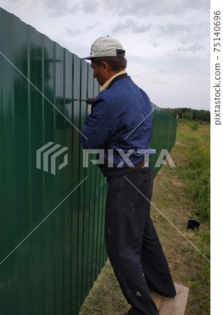 Fastening of a metal sheet to a framework of a fence by means of the screw-driver, screwing of screw-drivers in a fence. 75140696