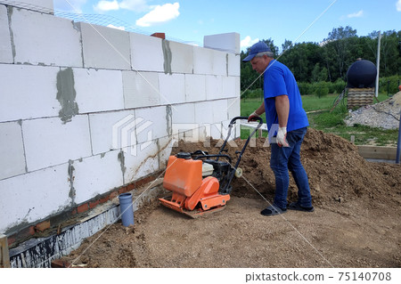 Use of a vibrating plate on construction, heavy construction tools and equipment, soil compaction with a vibrating plate. Use of a vibrating plate on construction, heavy construction tools and equipment, soil compaction with a vibrating plate. 75140708