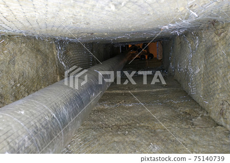 Installation of a ventilation pipe in the chimney, the pipe is wrapped with foil for cooling. Installation of a ventilation pipe in the chimney, the pipe is wrapped with foil for cooling. 75140739