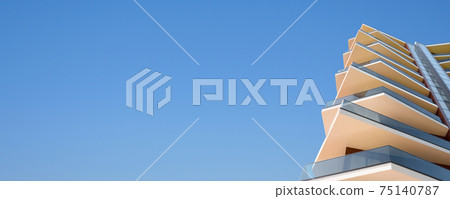 Organic home modern building facade hotel architecture property banner. Banner real estate design contemporary residential building architecture facade with balcony glass and concrete a clear blue sky Organic home modern building facade hotel architecture property banner. Banner real estate design contemporary residential building architecture facade with balcony glass and concrete a clear blue sky 75140787