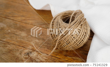 Skeins of jute rope on wooden table flat lay background with copy space. 75141329