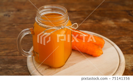 Carrot juice on a wooden background 75141356