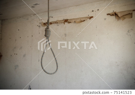 Deadly loop hanging from the ceiling in abandoned apartment. Concept of suicide, despair 75141523