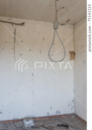 Deadly loop hanging from the ceiling in abandoned apartment. Concept of suicide, despair 75141524